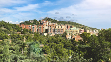 Obraz premium Apartment buildings surrounded by trees on hills