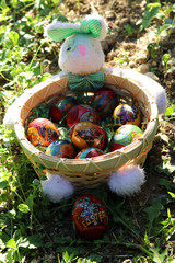 easter eggs in wooden basket with stuffed bunny
