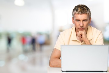 Smiling African Student man with laptop, mall background, bokeh