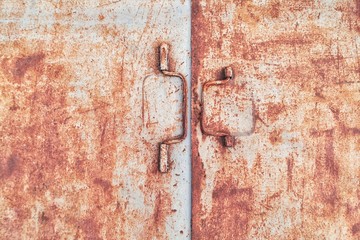 Old rusty iron door with two handles close-up. With selectiv focus. Copy space for text. 