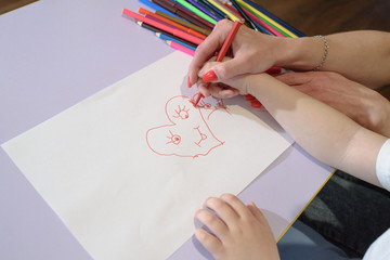 Happy mom and son draw and rejoice at home