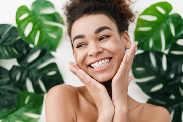 African-american girl with perfect skin over tropical leaves