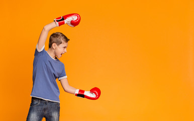 Furious teenager in boxing gloves screaming and attacking