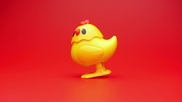 Clockwork yellow toy chicken. Clockwork chick toy hopping around. 