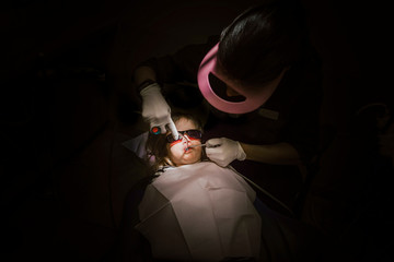 Toddler girl having her teeth fixed by dentist