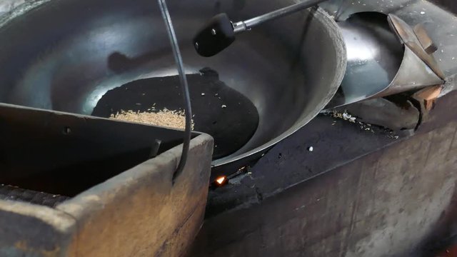 Making puffed rice in metal pan.