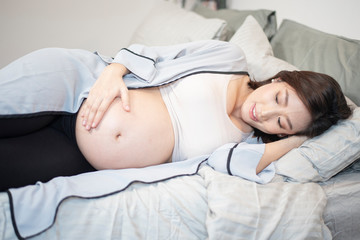 Beautiful asian pregnant woman is sleeping on bed