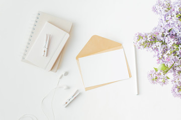 Mockup white greeting card and envelope with branches of lilac on a light background