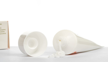 Gel, cream, ointment for external use squeezed out of a tube and the cover next to a white background