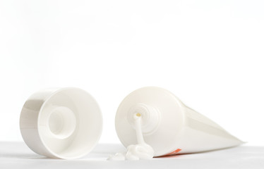 Gel, cream, ointment for external use squeezed out of a tube and the cover next to a white background
