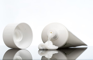 Gel, cream, ointment for external use squeezed out of a tube and the cover next to a white background