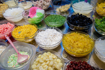 Mix dessert with ice, sweet and herb on sale. Varieties of colorful Thai dessert. Topping mixed for Thai ice dessert. Thai sweet dessert Khanom Thai and fruit bar with variety of raw.