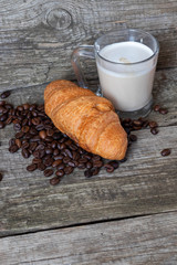 French breakfast with croissant and cappuccino over wooden background