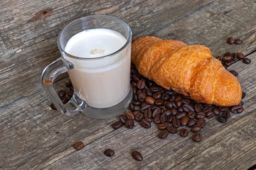French breakfast with croissant and cappuccino over wooden background