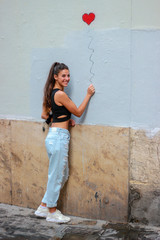 Trendy beautiful long haired young model posing on graffiti background