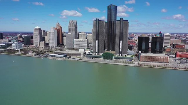 Aerial Tilt Up Reveal Shot of the Renaissance Center in Detroit from Over the Detroit River on a Beautiful Day with a Bright Blue Sky