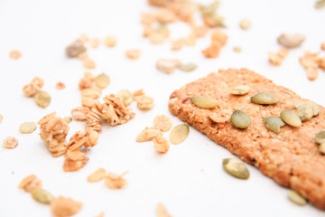 muesli cookies sprinkled with pumpkin seeds, isolated on a white background, selective focus. Top view