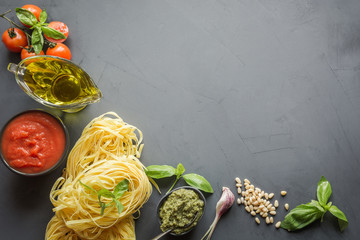 Pasta ingredients for cooking Italian dishes, tagliatelle, tomatoes, basil, oil and garlic. - obrazy, fototapety, plakaty