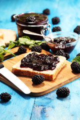 Toast bread with homemade blackberry jam or marmalade on table served with butter for breakfast or brunch