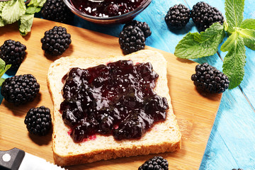 Toast bread with homemade blackberry jam or marmalade on table served with butter for breakfast or brunch