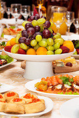 Luxurious table setting for a wedding or a holiday with beautiful fresh fruits and berries in a vase