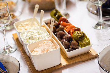 ariety of appetizers - olive paste, mayonnaise and other. Dinner table set up.