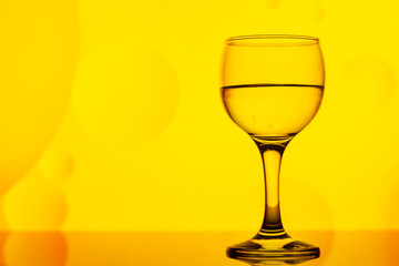 transparent glass with water and oily drops on background 
