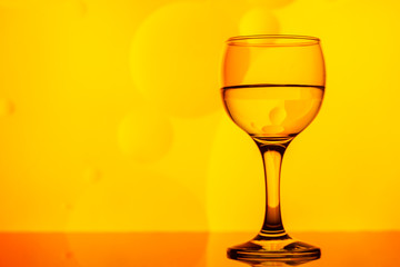 transparent glass with water and oily drops on background 