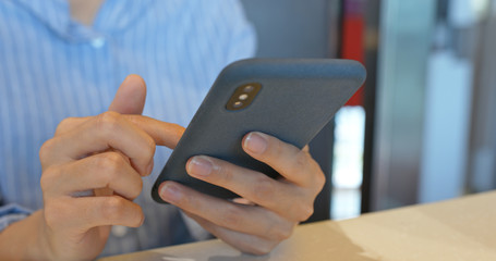 Woman use of mobile phone for order food with app in coffee shop