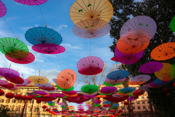 Colorful paper umbrellas on the sky background