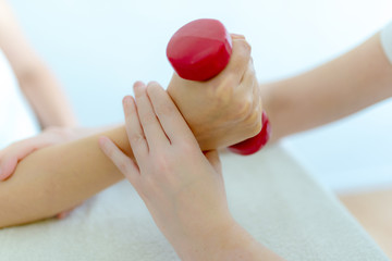 Physiotherapeutin macht Übungen mit Gewichten