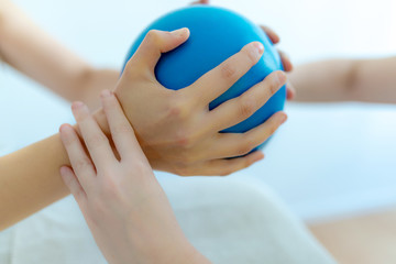 Physiotherapeutin macht Übungen mit Pilates Ball