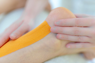 Physiotherapeutin klebt ein Tape, Faszien Dehnung