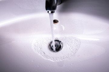 Water flows into the sink with drain plug