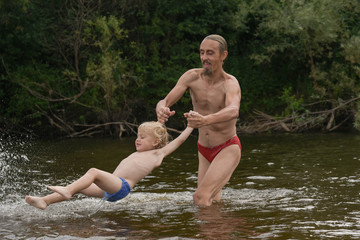 father teaching his little son to swim, they are happy.