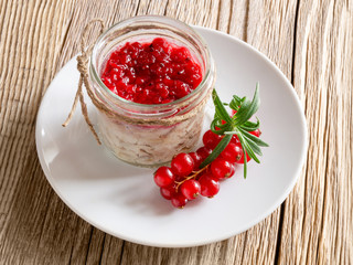 hot smoked mackerel rillettes with jam of red currants, rosemary, and white wine in a glass jar on wooden background