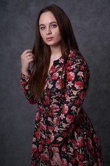 Portrait of a female in a colored dress on gray background