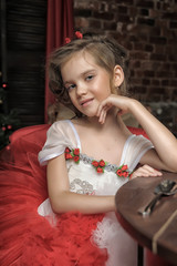young princess in a red and white dress sitting