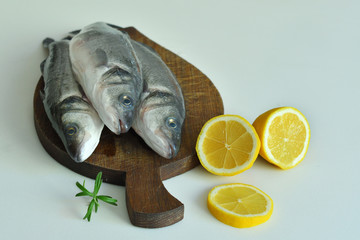 fresh fish with lemon and Rosemary on wooden board. mediterranean diet . healthy food