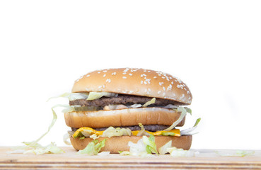 Burger on a white background. Cutlets bun sesame, cheese salad dressing. Improper nutrition. Unhealthy food.