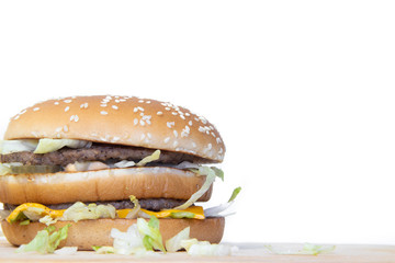 Burger on a white background. Cutlets bun sesame, cheese salad dressing. Improper nutrition. Unhealthy food.
