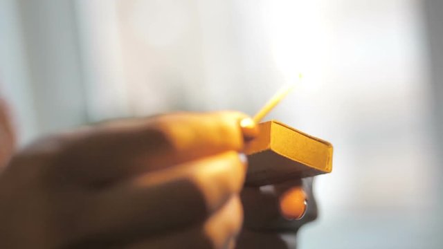 Girl's hand striking a match