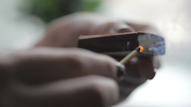 Girl's hand striking a match