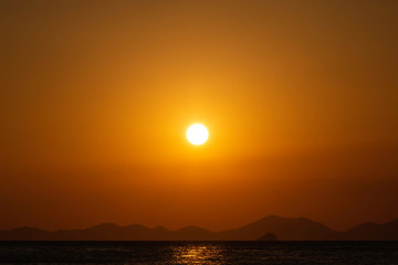 Golden sunset over the sea, mountain lines at background. Eighty percent of copy space in the picture