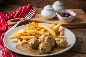 Meatballs with french fries in dill sauce.