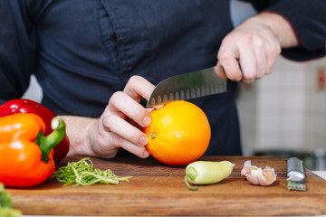 Chef cut orange. Fruit. Citrus. Wooden. Kitchen. Healthy food. Raw.