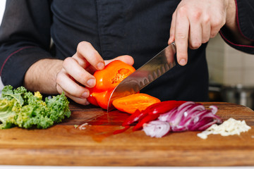 Chef cut onion and vegetables. Wooden. Kitchen. Healthy food. Raw.