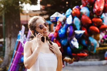 Laughing latin girl portrait, female teenager at smart phone outdoor in a colonial city in Mexico