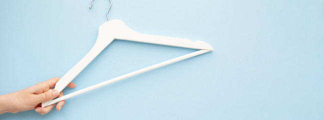 White wooden hangers on blue background