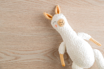 Craft toys for kids. Handmade lama. Wooden background top view mock up